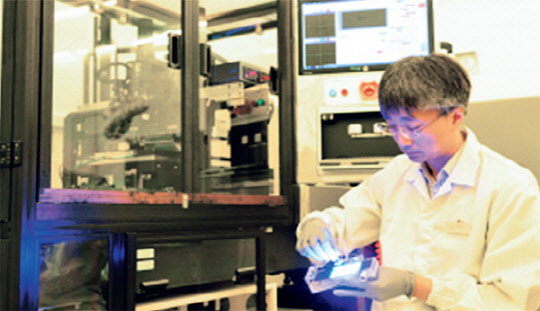 김재현 한국기계연구원 나노응용역학연구실 실장이 롤 전사 공정 장비로 제작한 마이크로 LED 디스플레이 샘플을 확인하고 있다. 기계연 제공